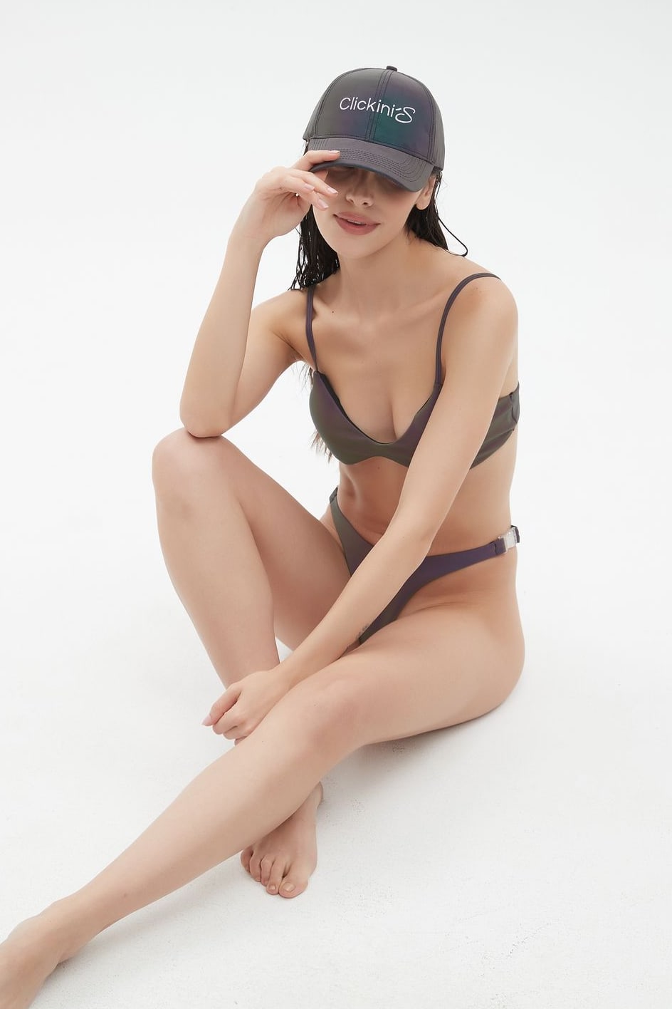 Clickinis bikini on a model seated on the floor with the cap, without flash